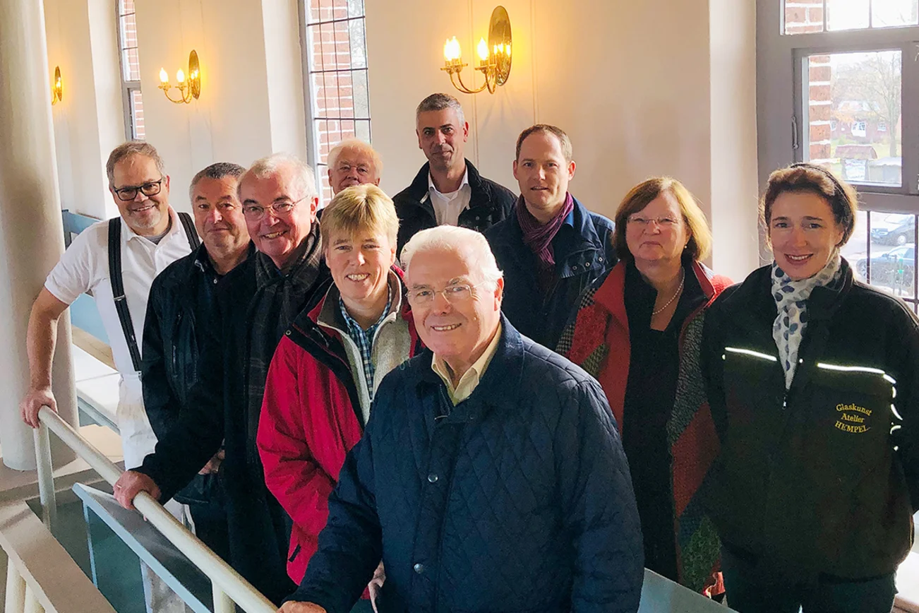 Malermeister Rainer Storbeck, Jens Meyer-Urban, Prof. Dr. Paul Georg Lankisch, Christine Fust, Jürgen Perau (vorn v. li.) sowie Helmut Schlingemann, Andreas Tech, André Schlesselmann (Fundraiser im Kirchenkreis Lübeck-Lauenburg), Pastorin Christel Rüder und Corinna Hempel vor den oberen restaurierten Kirchenfenstern. 