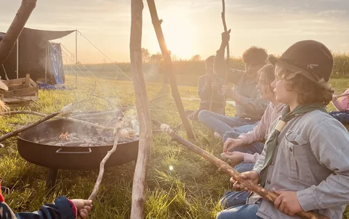 Pfadfinder grillen am Lagerfeuer
